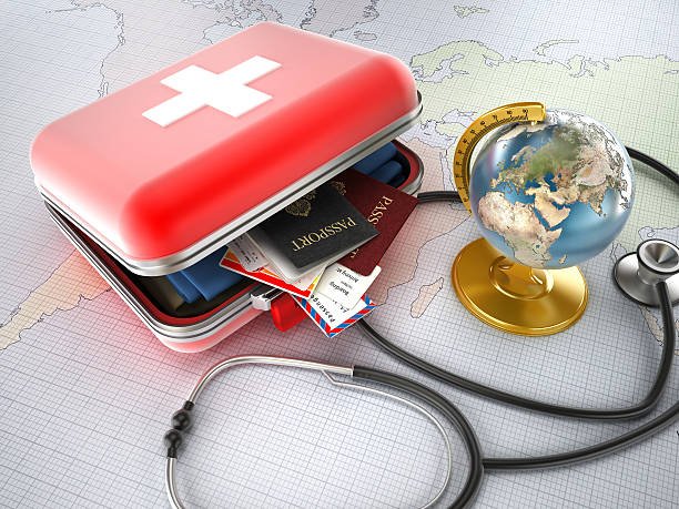 A red first aid kit is open and contains passports and medical documents, with a stethoscope nearby and a globe on a map background.